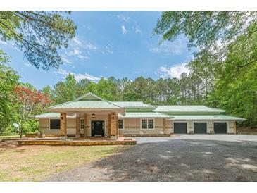 Beautiful single-story home with a long porch and attached three-car garage at 379 Bohannon Rd, Grantville, GA 30220