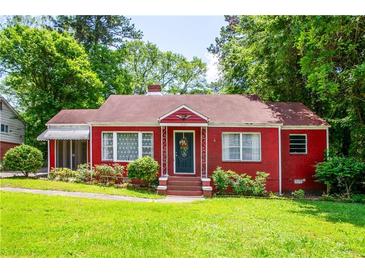 Charming red brick home with a well-manicured lawn and lush green trees at 3020 Washington Rd, East Point, GA 30344