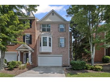 Beautiful brick townhome with attached garage and manicured landscaping at 5159 Wellsley Bnd, Alpharetta, GA 30005