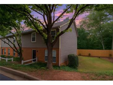 Charming townhouse with a mix of brick and siding, complemented by mature trees and a well-maintained lawn at 7750 Roswell Rd # 3D, Atlanta, GA 30350