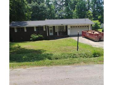 An exterior view of the property with a red dumpster and an attached garage at 1024 Topaz Lane, Villa Rica, GA 30180