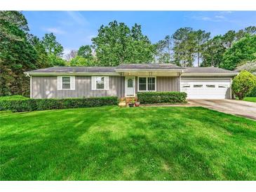 Charming single-story home with a well-manicured lawn and mature trees at 57 Fair Oaks Se Dr, Conyers, GA 30094