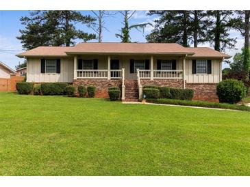 Charming ranch-style home featuring a brick foundation, covered porch, and a well-manicured lawn at 3802 Birchbriar Ct, Decatur, GA 30034