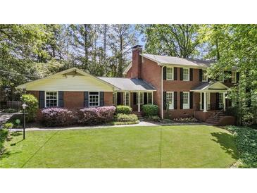 Charming brick home featuring a well-manicured lawn and mature landscaping at 4243 Mcclatchey Ne Cir, Atlanta, GA 30342