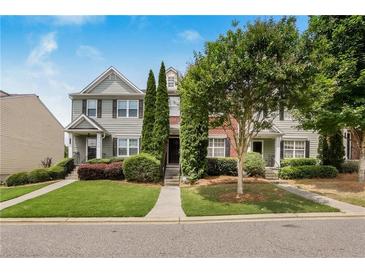 Inviting townhome featuring manicured landscaping and a charming facade at 1122 Cotton Gin Dr, Woodstock, GA 30188