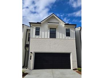 Two-story home with painted brick, vertical siding, and a two-car garage door at 1888 Copelyn Reese Court (Lot 164), Lawrenceville, GA 30043