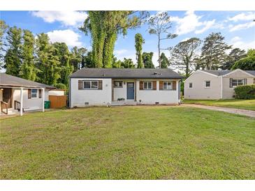 Charming one-story home with white painted brick, wood shutters, and a spacious front lawn at 2677 Tilson Rd, Decatur, GA 30032