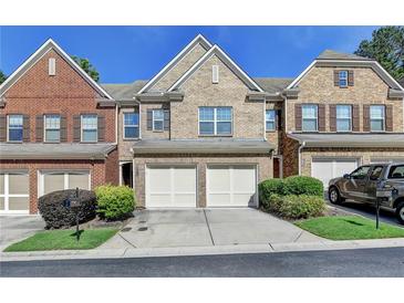 Charming townhome with brick facade, two-car garage, and well-maintained landscaping at 3351 Vintage Se Cir, Smyrna, GA 30080