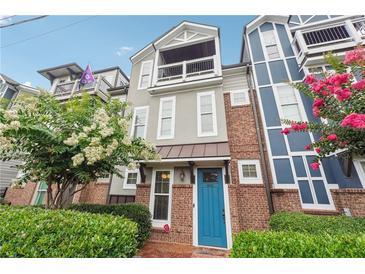 Charming two-story home with a balcony, brick accents, manicured landscaping, and a bright blue front door at 1802 Dekalb Ne Ave, Atlanta, GA 30307