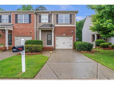 Attractive townhouse with brick and siding, well-maintained landscaping, and a private driveway at 2735 Maple Park Pl # 32, Cumming, GA 30041