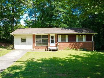Charming single-story home with a brick facade, a well-maintained lawn, and mature trees creating a serene and inviting atmosphere at 7125 Chappell Cir, Atlanta, GA 30360