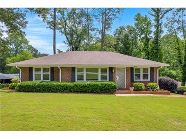 Charming, one-story brick home featuring a well-manicured lawn and lush shrubbery at 2320 Tilson Cir, Decatur, GA 30032