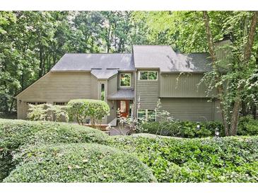 Charming two-story home with wood siding, mature landscaping, and inviting curb appeal at 4246 Loch Highland Ne Pkwy, Roswell, GA 30075