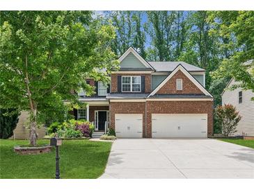 Charming brick two-story home featuring a two-car garage and a beautifully landscaped front yard at 5655 Stevehaven Ln, Cumming, GA 30028