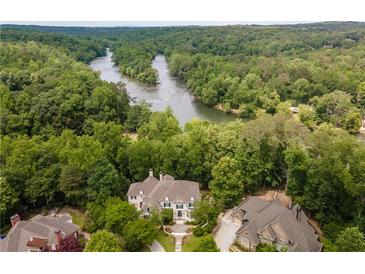 Stunning aerial view of estate home on a wooded lot with river frontage at 8470 Lazy Oaks Ct, Atlanta, GA 30350