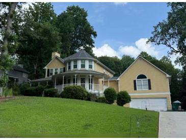 Charming two-story home with a manicured lawn, a welcoming porch, and an attached two-car garage at 1713 Dudley Dr, Woodstock, GA 30188