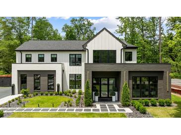 Striking modern home with black trim, white siding, and professionally landscaped front yard at 185 Pebble Trl, Alpharetta, GA 30009