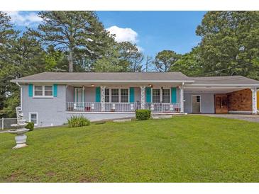 Charming one-story home featuring a covered porch with decorative railings and an attached carport at 4002 Phylis Pl, Decatur, GA 30035