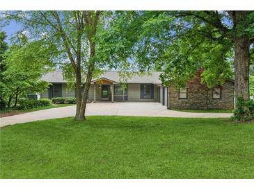 Ranch-style home with beautiful landscaping, mature trees, and a long driveway at 2055 Cactus Ln, Cumming, GA 30040