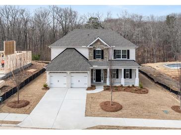 New two-story home boasts a symmetrical facade, attached two-car garage, and a well-manicured lawn at 7169 Linden Dr, South Fulton, GA 30349