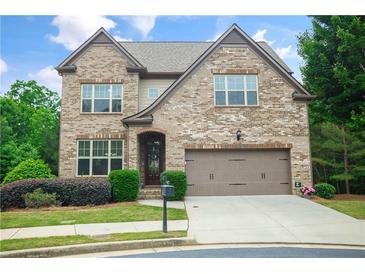Charming two-story brick home with a well-manicured lawn and a two-car garage at 3920 Baverton Dr, Suwanee, GA 30024