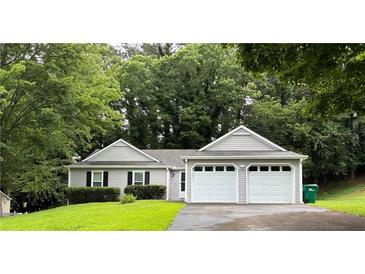 Charming single-story home with a two-car garage and well-maintained lawn and mature landscaping at 225 Magnolia Tree Ct, Johns Creek, GA 30022