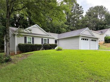 Single story home with two-car garage and lawn at 225 Magnolia Tree Ct, Johns Creek, GA 30022