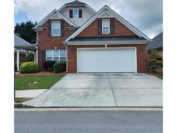 Charming brick home with a well-maintained lawn, two-car garage, and inviting curb appeal at 1885 Hickory Station Cir, Snellville, GA 30078