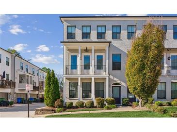 Beautiful gray brick townhome with a small front yard and two-story porch at 2034 Rockledge Ne Rd, Atlanta, GA 30324