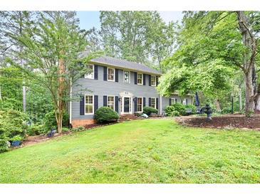 Charming two-story home with beautiful lawn, manicured shrubs, and a symmetrical facade at 2041 Millspring Nw Way, Kennesaw, GA 30152