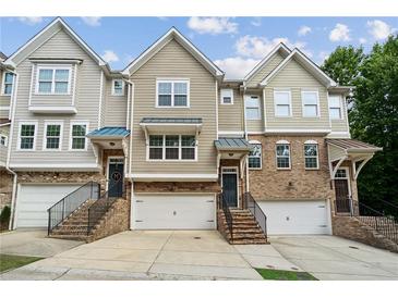 Charming townhomes featuring a brick facade, individual garages, and inviting front entrances at 4173 Chatham Ridge Dr, Buford, GA 30518