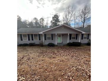 Charming ranch-style home featuring gray siding, black shutters, and a well-manicured front yard at 6540 Old White Mill Road Rd, Fairburn, GA 30213