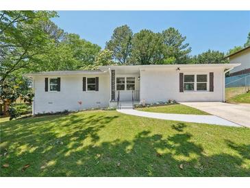 Charming exterior of home with manicured lawn, featuring a brick facade, dark shutters, and a concrete walkway at 2105 Royal Fox Way, Decatur, GA 30032