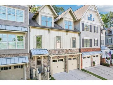 Charming townhome with stone accents, two-car garage, and a welcoming entrance at 238 Trecastle Sq, Canton, GA 30114