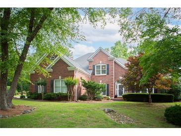 Charming brick home with lush landscaping, mature trees and a well-manicured lawn at 4645 Waterford Dr, Suwanee, GA 30024