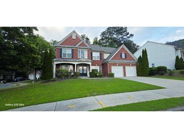 Charming two-story brick home with a well-manicured lawn and a two-car garage at 779 Avonley Creek Trce, Sugar Hill, GA 30518