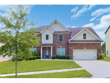 Charming two-story brick home featuring a well-manicured lawn, attached garage, and welcoming entrance at 1433 Sand Way, Lawrenceville, GA 30045