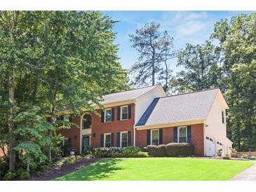 Charming two-story brick home with black shutters, manicured lawn, and mature trees adding curb appeal at 3837 Fenway Xing, Marietta, GA 30062
