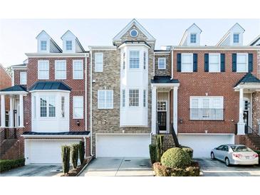 Beautiful townhome with a brick facade, bay windows, and attached garages for convenient parking at 1292 Creekside Se Ter, Smyrna, GA 30082