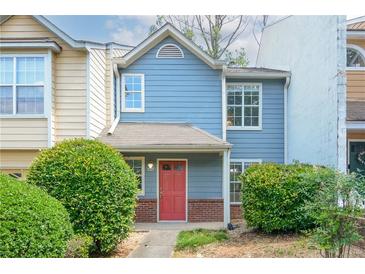 Charming townhome featuring a red door, light blue siding, brick accents, and well-maintained landscaping at 3263 Long Iron Pl, Lawrenceville, GA 30044