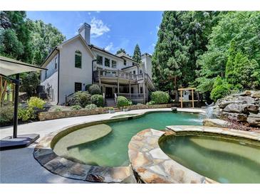 Inviting backyard pool and spa with waterfall feature and lush landscaping at 7920 Tintern Trce, Duluth, GA 30097