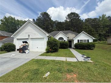 Charming single-story home with white siding, green lawn, and a two-car garage and mature trees at 160 Goldleaf Dr, Hampton, GA 30228