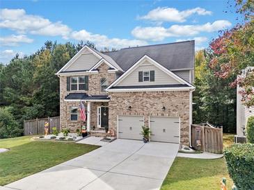 Charming two-story brick home with a well-manicured lawn, two-car garage and beautiful landscaping at 3865 Brookhollow Dr, Douglasville, GA 30135