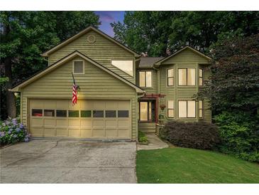 Charming two-story home featuring a two-car garage, lush landscaping, and a welcoming front entrance at 265 Lee River Cv, Suwanee, GA 30024