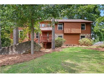Charming two-story home with a mix of wood and stone accents, surrounded by lush greenery at 3007 Manning Dr, Marietta, GA 30062