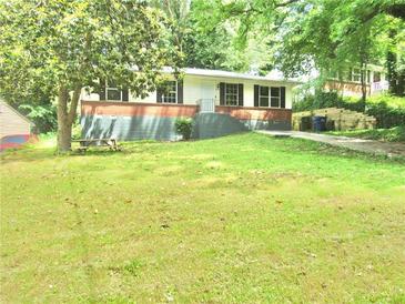 Charming home featuring a well-maintained front yard with mature trees, picnic table, and a classic exterior at 3086 Lone Oak Sw Ave, Atlanta, GA 30354