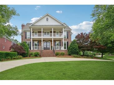 Beautiful two-story brick home featuring a double porch, manicured lawn and mature trees at 230 Summerhouse Ln, Atlanta, GA 30350