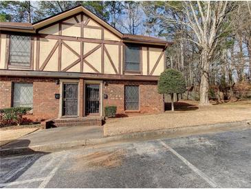 A brick townhome featuring a Tudor-style facade with decorative timber accents and mature trees at 3252 Abbeywood Dr, Decatur, GA 30034