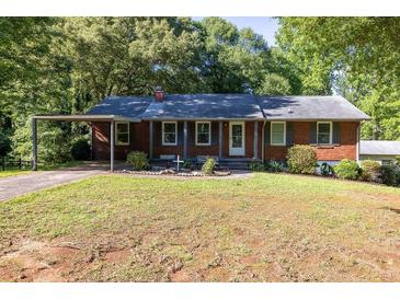 Charming brick home with a well-manicured lawn and covered parking at 4370 Tradition Ter, Austell, GA 30106