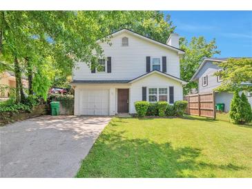 Charming two-story home with a well-manicured lawn and attached garage, framed by mature trees at 912 Third St, Stone Mountain, GA 30083